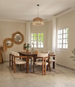 a dining room with a table and chairs at Akasha Villa in Madīnat ash Shurūq