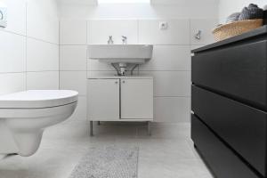 une salle de bain blanche avec un lavabo et des toilettes dans l'établissement Charming apartment in Miesenheim, à Andernach 12 autres photos