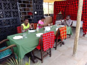 a group of people sitting at a table in a restaurant at Ndege Mingi Bush Camp - Laikipia in Nanyuki