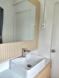 a bathroom with a white sink and a mirror at Pause Homestay 2 Hat Yai in Hat Yai