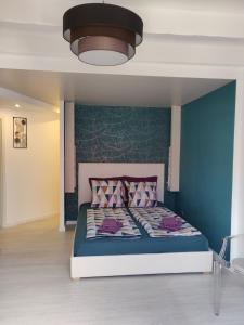 ein Schlafzimmer mit einem Bett mit einer blauen Wand in der Unterkunft Au bon repos - Escapade idéale au cœur de l'Alsace in Muttersholtz