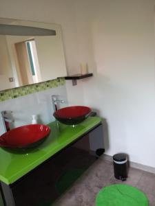 Ein Badezimmer mit zwei roten Waschbecken auf einer grünen Arbeitsplatte in der Unterkunft Au bon repos - Escapade idéale au cœur de l'Alsace in Muttersholtz