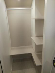 einen weißen begehbaren Kleiderschrank mit weißen Regalen in der Unterkunft Au bon repos - Escapade idéale au cœur de l'Alsace in Muttersholtz