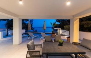 a patio with a table and chairs and a view of the ocean at Villa Palazzo Maestral beachfront by Villas Guide in Viniština