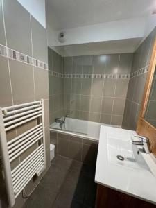 un baño con lavabo y bañera en Chalet Des Rennes - Super appartement Prestige dans une résidence avec piscine au pied des pistes, en Vars