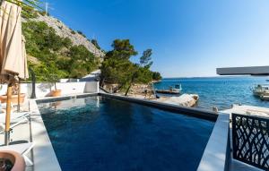 a swimming pool with a view of the ocean at Villa Palazzo Maestral beachfront by Villas Guide in Viniština