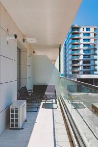 a balcony with chairs and tables on a building at Marcony Seaview Apartments in Mamaia