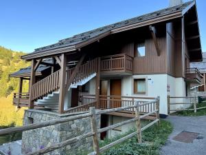 Una casa con una terraza envolvente con una cerca. en Chalet Des Rennes - Super appartement Prestige dans une résidence avec piscine au pied des pistes, en Vars