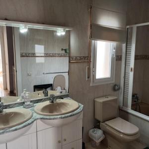 a bathroom with two sinks and a toilet and a mirror at casa Palm Beach in Montroig +10 photos