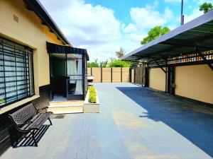 a patio with a bench next to a building at WinHaven Guest House in Randfontein