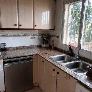 a kitchen counter with a sink and a window at casa Palm Beach in Montroig