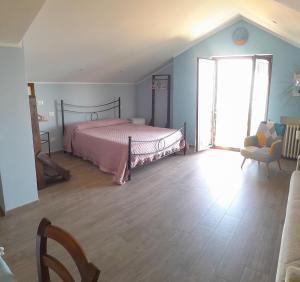 1 dormitorio con 1 cama con colcha rosa en Mansarda a Noli e Spotorno, en Noli