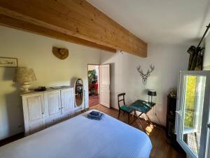 a bedroom with a large white bed and a table at Maison d'Artiste in La Celle-sous-Gouzon