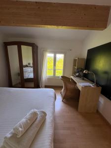 a bedroom with a bed and a desk and a window at Maison d'Artiste in La Celle-sous-Gouzon
