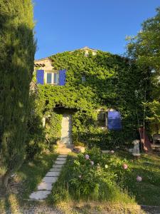 a house covered in ivy with a walkway at Maison d'Artiste in La Celle-sous-Gouzon
