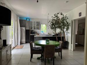 a kitchen with a green table and chairs in it at Maison d'Artiste in La Celle-sous-Gouzon