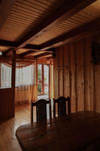 a dining room with a wooden table and two chairs at Котедж Арніка з Чаном in Vorokhta +30 photos