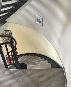 a spiral staircase in a house with a black railing at Ferienwohnung Silo Mit Kleinem Garten in Poppendorf
