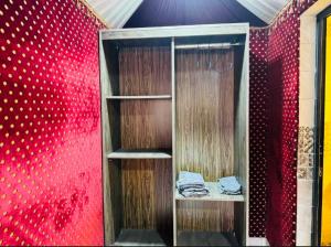 Habitación con pared roja y estante de madera. en Desert calm, en Wadi Rum