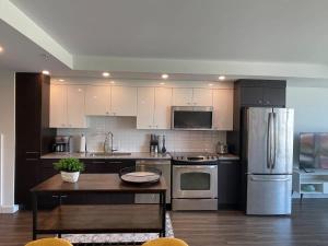 eine Küche mit Geräten aus Edelstahl und einem Tisch in der Unterkunft Bright 1 BR with Lots of Sunlight & 6 Appliances in Halifax