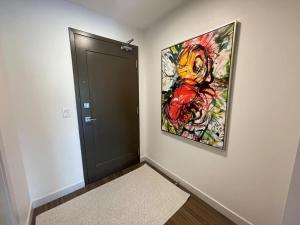 einen Flur mit einer Tür und einem Gemälde an der Wand in der Unterkunft Bright 1 BR with Lots of Sunlight & 6 Appliances in Halifax