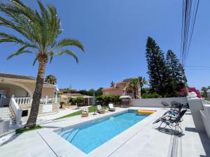 a villa with a palm tree and a swimming pool at R-70 Oasis in Ciudad Quesada