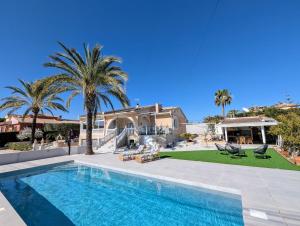 a house with a swimming pool and palm trees at R-70 Oasis in Ciudad Quesada