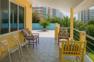 a porch with chairs and a table and chairs at Mansão Ouro Verde Beira Mar in Piçarras