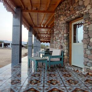 a patio with a table and a bench on a building at Shakazola Camp in Nuweiba