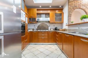 eine Küche mit Holzschränken und einem Edelstahlkühlschrank in der Unterkunft The Seagull - Quiet Retreat With Panoramic View in Nea Makri