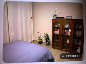 a bedroom with a bed and a book shelf with books at 혼자 여행하는 여성을 위한 안전한 숙소 