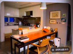 a kitchen with a wooden table and chairs at 혼자 여행하는 여성을 위한 안전한 숙소 