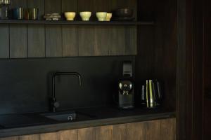 een aanrecht met een koffiezetapparaat en een wastafel bij Resort Wilsumer Berge in Wilsum