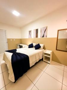 una camera da letto con un letto grande con cuscini blu di Via Brasil Hotel a São Luís