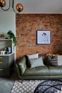 a living room with a leather couch against a brick wall at The Avenue in Launceston