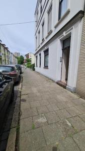 an empty street next to a white building at Deichliebe 3 - gemütlich, zentral und modern- Inklusive privater Stellplatz im Parkhaus 2min zu Fuß entfernt in Bremerhaven