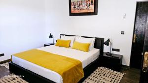 een slaapkamer met een groot bed met gele kussens bij l'oasis de paix refugee unique à Marrakech in Aït Amara +31 foto's