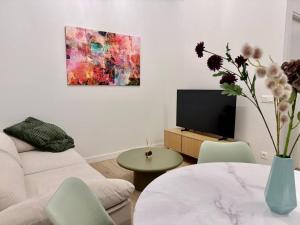 a living room with a couch and a vase with flowers at Nuevo, Verde y Acogedor in El Castellar
