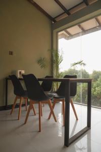 ディックウェラにあるBakamuna Villaのガラスのテーブルと椅子のあるダイニングルーム