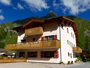 a building with a balcony with mountains in the background at Aparthotel Grischuna in Samnaun