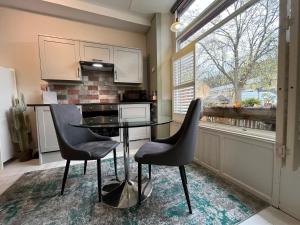a kitchen with a glass table and two chairs at Royd Villas Central Hebden Bridge in Hebden Bridge