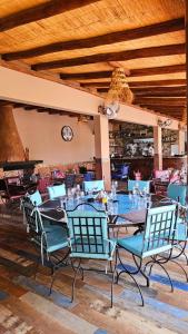 een eetkamer met stoelen en tafels en een klok bij l'oasis de paix refugee unique à Marrakech in Aït Amara