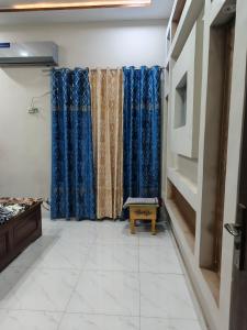 un pasillo con cortinas azules en una habitación en Marhaba Guest House Multan, en Multán