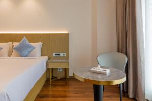 Un dormitorio con una cama, una mesa y una silla. en Coral Reef Kakkanad, en Kochi