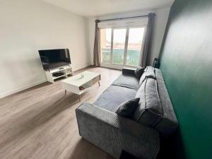 a living room with a couch and a tv at Le Vilmorin - Balcon - 4 prs - Proche Paris in Vitry-sur-Seine