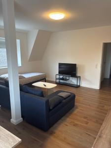 a living room with a couch and a tv at Erics Gästehaus in Uetersen