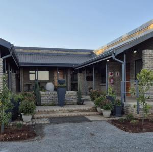 a brick house with stairs and potted plants at EveGreen Guest Lodge in Derby