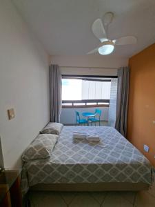a bedroom with a bed with a blue chair in it at Ap Orla de Aracaju in Aracaju