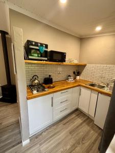 eine Küche mit weißen Schränken und einer Arbeitsplatte in der Unterkunft Meadow Lane Country Cottages in Underberg