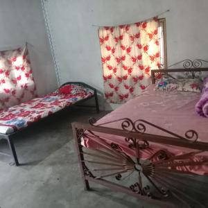 a bedroom with two beds and a window at Ecopark Homestay in Bharatpur
